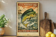 A vintage U.S. postage stamp featuring a fish, likely a Mahi-Mahi, is displayed on a wooden surface next to a potted plant and a wooden cutting board.