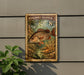 A vintage postage stamp featuring a fish, likely a Mangrove Snapper, is displayed on a wall next to a plant.