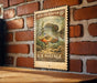 A vintage-style postage stamp featuring a sunfish, mounted on a brick wall.