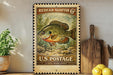 A vintage-style stamp featuring a sunfish, with text indicating it is a Redear Sunfish 6¢ from the U.S. Postal Service. The stamp is displayed on a wooden surface, with a potted plant and a wooden cutting board visible in the background.