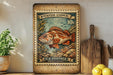 A vintage-style postage stamp featuring a rockfish, with the text "ROCKFISH (COpper) 10c" and "U.S. POSTAGE SEBASTES CAURINIS". The stamp is displayed on a wooden surface, with a potted plant, a cutting board, and some lemons nearby.