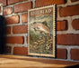 A vintage-style postage stamp featuring a fish illustration is displayed on a brick wall.