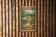 A U.S. postage stamp featuring a striped bass is displayed on a wooden wall.