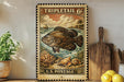 A vintage-style postage stamp featuring a large fish, surrounded by a tropical landscape, is displayed on a shelf next to a wooden cutting board and a potted plant.
