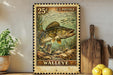 A vintage-style U.S. postage stamp featuring a walleye fish, displayed on a wooden surface next to a wooden cutting board and a potted plant.
