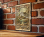 A vintage U.S. postage stamp featuring a fish, mounted on a brick wall.