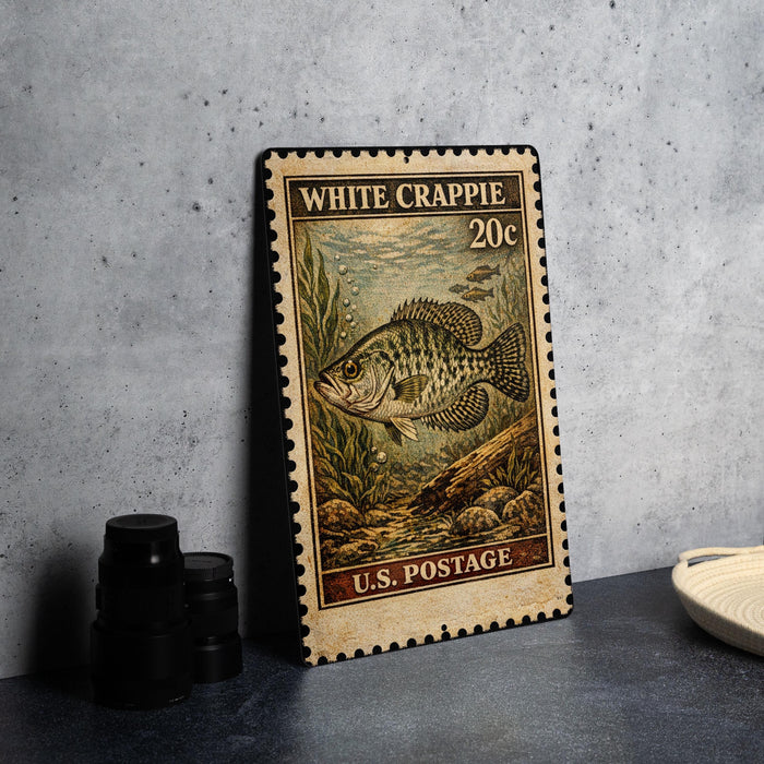 A vintage-style postage stamp featuring a fish, likely a White Crappie, on a gray background.