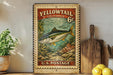 A vintage-style postage stamp featuring a fish, with the text "Yellowtail California 6c" and "U.S. Postage" printed on it. The stamp is displayed on a shelf next to a wooden cutting board and a potted plant.