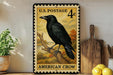 A U.S. postage stamp featuring an American crow, placed on a wooden surface next to a wooden cutting board and some lemons.