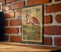 A vintage American postage stamp featuring a pink flamingo is displayed on a brick wall.