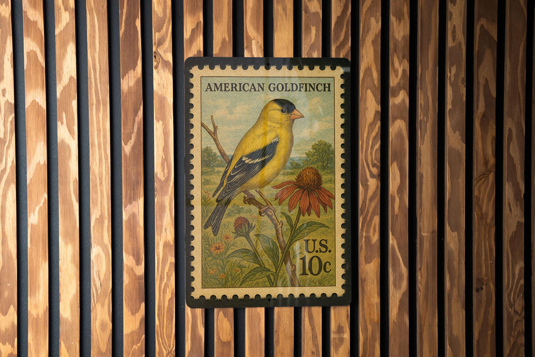A postage stamp featuring an American Goldfinch, with a vibrant illustration of the bird perched on a branch and a flower nearby.