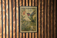 A vintage postage stamp featuring a colorful illustration of a hummingbird perched on a flower, set against a wooden background.