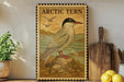 a framed illustration of an Arctic tern, a bird known for its distinctive appearance and habitat. The bird is depicted in a natural setting, with a rocky outcrop and a body of water in the background. The frame has a decorative border, and the text "ARCTIC TERN" is prominently displayed.