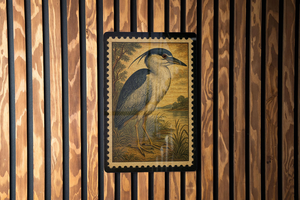 a framed illustration of a bird, likely a heron, displayed on a wooden wall.
