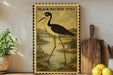 a framed illustration of a black-necked stilt standing on a pond, surrounded by a lush green landscape.