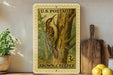 A framed U.S. postage stamp depicting a brown creeper perched on a tree, with a wooden cutting board and lemons visible in the background.