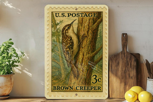 A framed U.S. postage stamp depicting a brown creeper perched on a tree, with a wooden cutting board and lemons visible in the background.