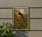 A vintage Bullock's Oriole postage stamp is displayed on a wall, featuring a detailed illustration of the bird perched on a branch.