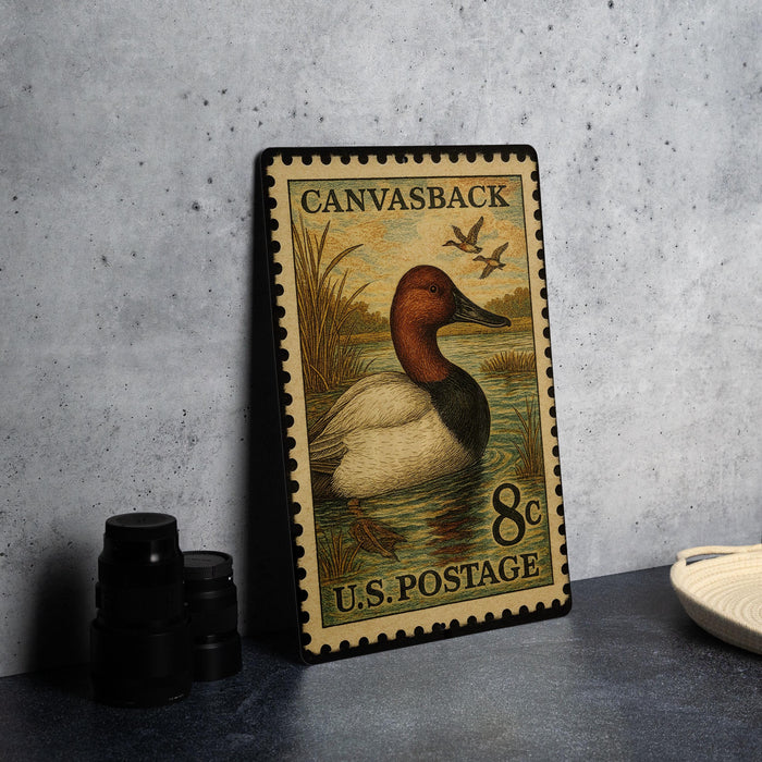 A vintage postage stamp featuring a duck on a pond, with the text "Canvasback 8c U.S. Postage".
