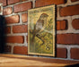 A vintage postage stamp featuring a chipping sparrow is displayed on a brick wall.