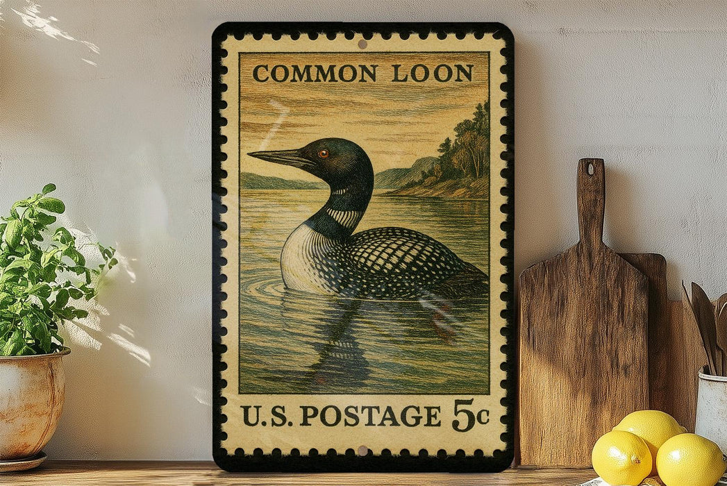 A framed postage stamp depicting a loon is displayed on a shelf, surrounded by kitchen utensils and a potted plant.