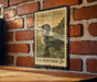 A vintage U.S. postage stamp featuring a loon is displayed on a brick wall.
