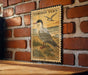 a vintage-style stamp or sign with a bird illustration, mounted on a brick wall.