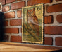 A vintage Eastern Screech Owl postage stamp is displayed on a brick wall, with a wooden table below it.