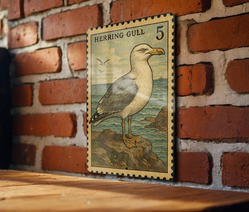 A framed postage stamp depicting a seagull is hanging on a brick wall.