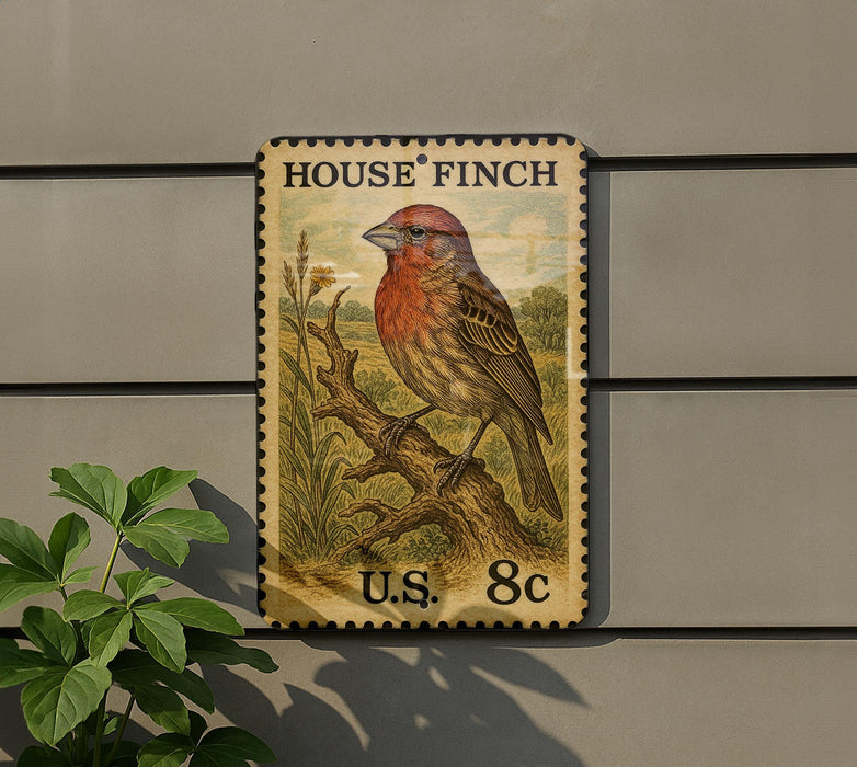 A vintage-style postage stamp featuring a colorful illustration of a House Finch perched on a branch, mounted on a wall next to a plant.