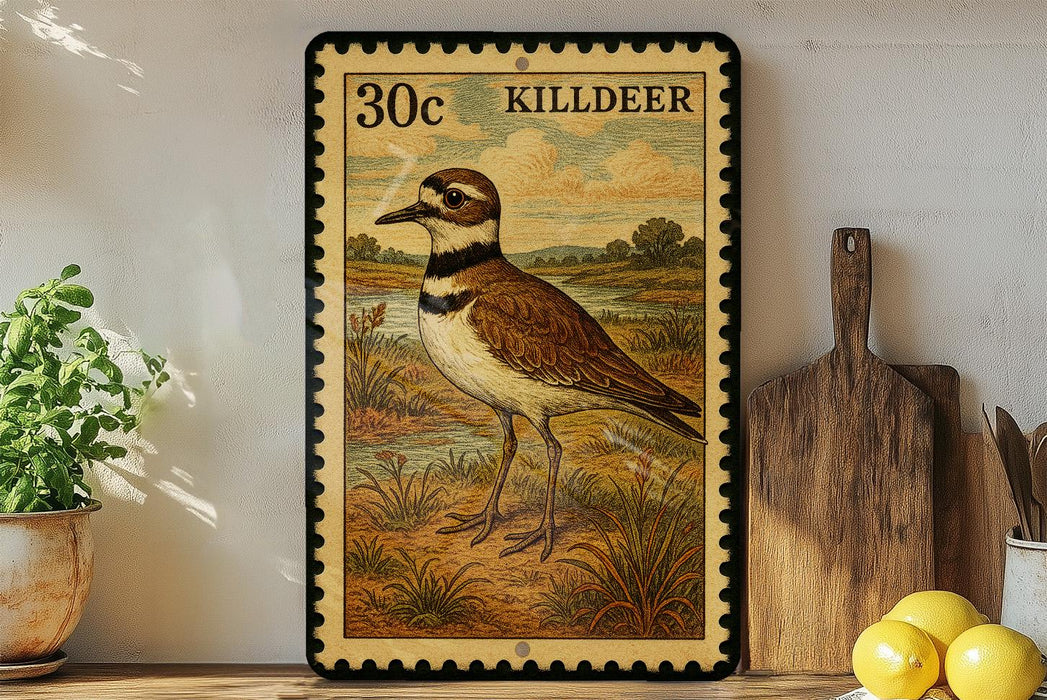 A framed postage stamp depicting a bird, specifically a killdeer, is displayed on a shelf next to a wooden cutting board and some kitchen utensils.