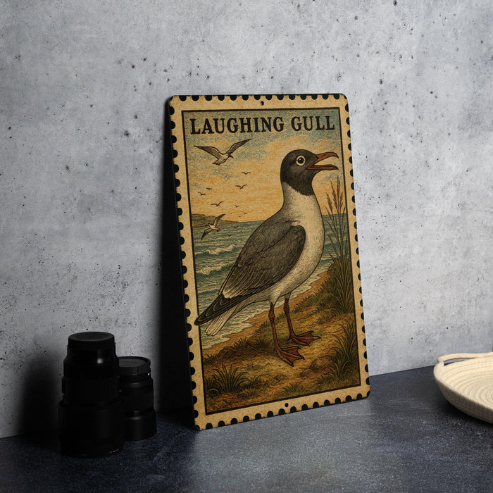 A framed illustration of a laughing gull is displayed on a wall, with a plate and a stack of black camera lenses to the left.