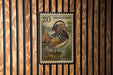 A postage stamp featuring a colorful illustration of a mandarin duck.