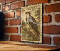A vintage postage stamp featuring an illustration of an Osprey, a large bird of prey, is displayed on a brick wall.
