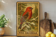 A framed illustration of a red bird, possibly a pine grouse, perched on a branch with pine trees in the background.