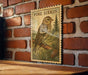 A framed illustration of a bird, likely a pine siskin, is displayed on a brick wall.