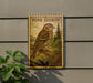 A wooden sign with a bird illustration is mounted on a wall, with a plant to the left of the sign.