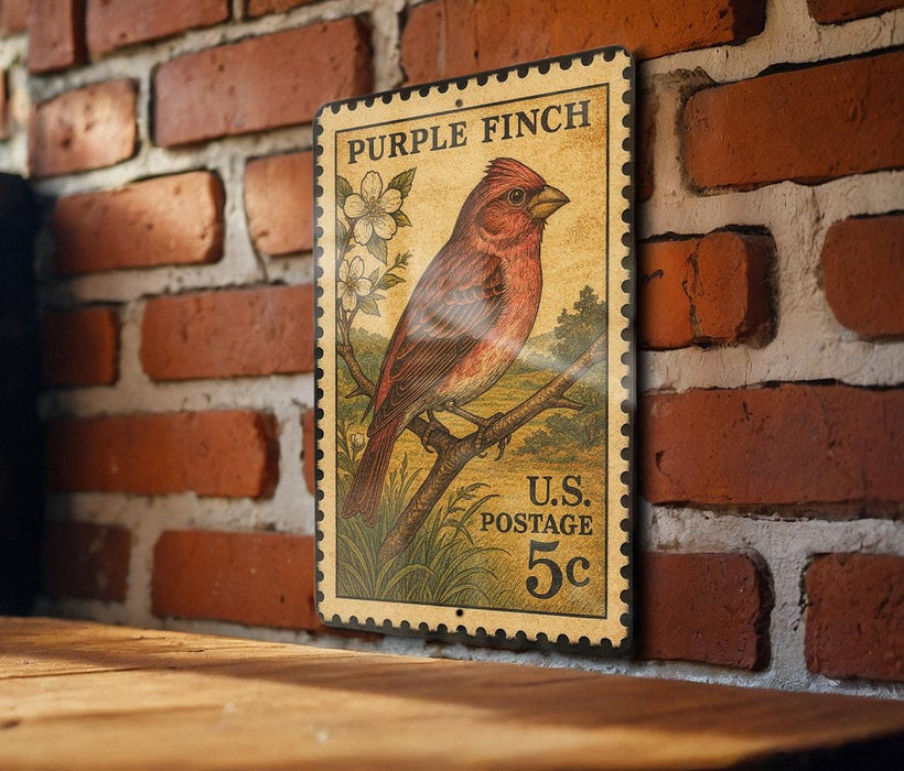 A vintage purple finch postage stamp is displayed on a brick wall, with a wooden table below it.