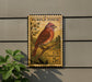 A vintage Purple Finch postage stamp is displayed on a wall, featuring a detailed illustration of the bird perched on a branch.