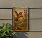 A postage stamp featuring a colorful hummingbird is displayed on a wall, with a plant in the foreground.