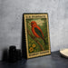 A U.S. postage stamp featuring a red bird, specifically a scarlet tanager, perched on a branch.