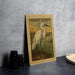 a framed illustration of a snowy egret standing in a grassy field, with a stamp-like border around the edges.