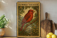 a framed illustration of a red bird perched on a branch, surrounded by lush greenery, with a wooden cutting board and a potted plant nearby.