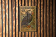 A U.S. postage stamp featuring a puffin bird, which is a type of seabird, is displayed on a wooden wall.