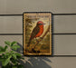 a large, detailed illustration of a red bird perched on a branch, mounted on a wall.