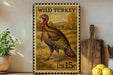 A framed stamp depicting a wild turkey, with the text "WILD TURKEY" and "us.15c" printed on it. The stamp is placed on a shelf next to a wooden cutting board and a potted plant.