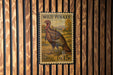 A vintage-style postage stamp featuring a turkey, mounted on a wooden wall.