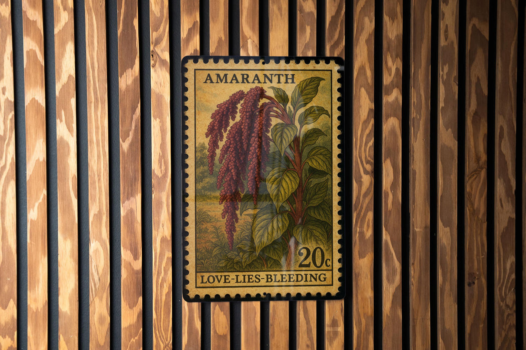 a postage stamp from Amaranth, depicting a plant with red berries and green leaves, hanging on a wooden wall.