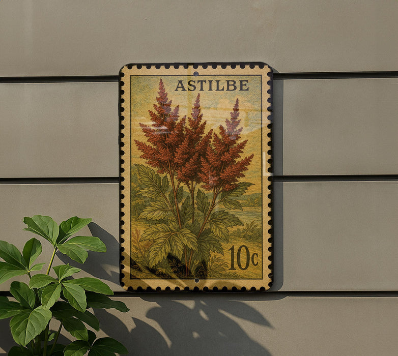 A postage stamp featuring a plant with red flowers is displayed on a wall, next to a small green plant.