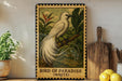 A framed illustration of a white bird, possibly a parrot, perched on a branch with tropical foliage, is displayed on a shelf next to a wooden cutting board and a potted plant.